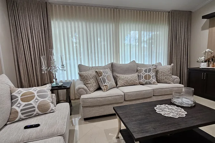 Sala familiar cálida con cortinas dobles: sheer blanco y drape decorativo