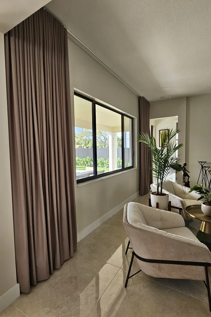 Rincón elegante con cortina de piso a techo en tono taupe